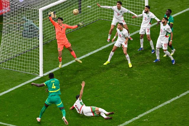 Senegal's defender #04 Abdoulaye Seck heads the ball in front of Morocco's goalkeeper #01 Yassine Bounou during the Africa Cup of Nations (CAN) final football match between Senegal and Morocco at the Prince Moulay Abdellah Stadium in Rabat on January 18, 2026. (Photo by Paul ELLIS / AFP)