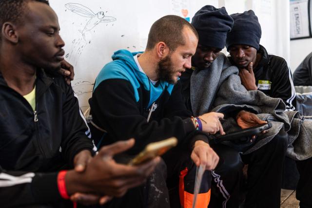 Migrants send messages to their relatives using the Telecoms Without Borders (TSF) service onboard the rescue ship "Ocean Viking" operated by the NGO SOS Mediterranee, as it sails toward a distress case in the search-and-rescue zone in international waters off the coast of Libya, on January 17, 2026. (Photo by Sameer Al-DOUMY / AFP)
