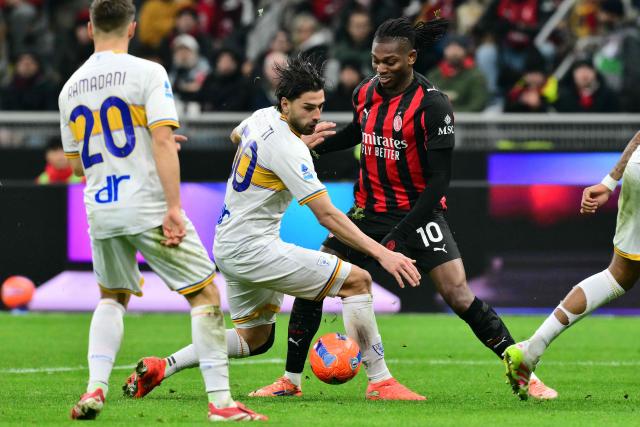 Lecce's Argentine forward #50 Santiago Pierotti fights for the ball with AC Milan's Portuguese forward #10 Rafael Leao during the Italian Serie A football match between AC Milan and Lecce at San Siro stadium in Milan, northern Italy, on January 18, 2026. (Photo by Stefano RELLANDINI / AFP)