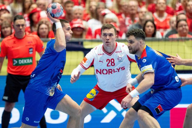 Denmark's left back #28 Lasse Andersson (C) vies for the ball with Romania's left back #41 Razvan Cristian Trif and Romania's pivot #11 Robert Nagy during the men's EHF Euro 2026 preliminary round group B handball match Romania vs Denmark in Herning, Denmark, on January 18, 2026. (Photo by Bo Amstrup / Ritzau Scanpix / AFP) / Denmark OUT
