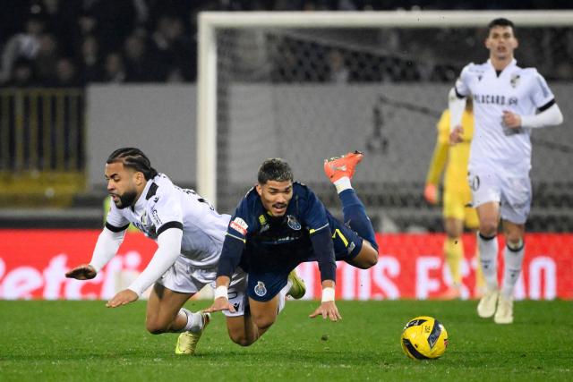 Vitoria Guimaraes's Portuguese midfielder # 18 Telmo Arcanjo and FC Porto's Brazilian forward #07 William Gomes fall down to the ground during the Portuguese league football match between Vitoria Guimaraes SC and FC Porto at Dom Afonso Henriques stadium in Guimaraes on January 18, 2026. (Photo by Miguel RIOPA / AFP)