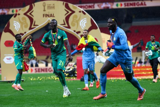 Senegal players celebrate their victory at the end of the Africa Cup of Nations (CAN) final football match against Morocco at the Prince Moulay Abdellah Stadium in Rabat on January 18, 2026. (Photo by FRANCK FIFE / AFP)
