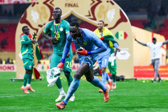 Senegal's goalkeeper #16 Edouard Mendy and his teammates celebrate their victory at the end of the Africa Cup of Nations (CAN) final football match against Morocco at the Prince Moulay Abdellah Stadium in Rabat on January 18, 2026. (Photo by FRANCK FIFE / AFP)