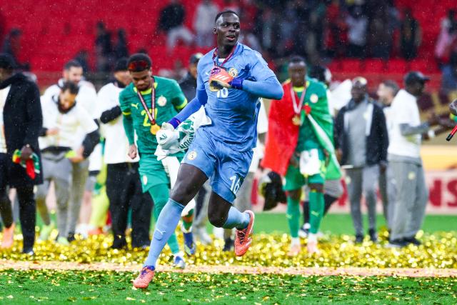 Senegal's goalkeeper #16 Edouard Mendy and his teammates celebrate their victory at the end of the Africa Cup of Nations (CAN) final football match against Morocco at the Prince Moulay Abdellah Stadium in Rabat on January 18, 2026. (Photo by FRANCK FIFE / AFP)