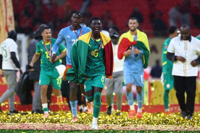 Senegal's midfielder #08 Lamine Camara and his teammates celebrate their victory at the end of the Africa Cup of Nations (CAN) final football match against Morocco at the Prince Moulay Abdellah Stadium in Rabat on January 18, 2026. (Photo by FRANCK FIFE / AFP)