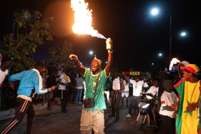 Senegal football supporters celebrate at a fan zone at the Obelisk Square in Dakar on January 18, 2026 after Senegal won the Africa Cup of Nations (CAN) final football match between Senegal and Morocco played in Rabat, Morocco. (Photo by SEYLLOU / AFP)