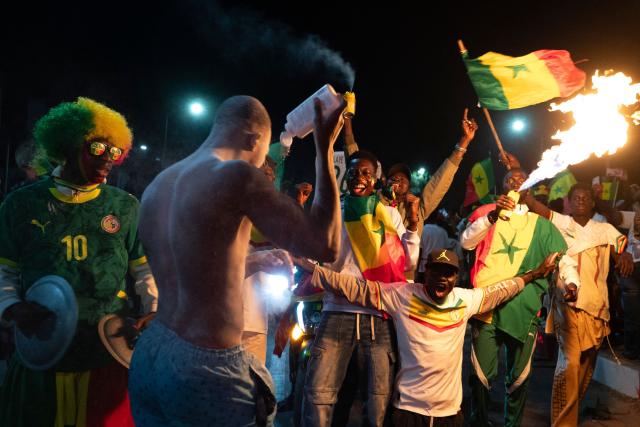 Senegal football supporters celebrate at a fan zone at the Obelisk Square in Dakar on January 18, 2026 after Senegal won the Africa Cup of Nations (CAN) final football match between Senegal and Morocco played in Rabat, Morocco. (Photo by SEYLLOU / AFP)