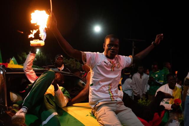 Senegal football supporters celebrate at a fan zone at the Obelisk Square in Dakar on January 18, 2026 after Senegal won the Africa Cup of Nations (CAN) final football match between Senegal and Morocco played in Rabat, Morocco. (Photo by SEYLLOU / AFP)