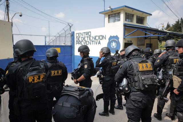 Members of the Guatemalan Police Special Forces Division (FEP) guard the entrance to the men's Preventive Detention Center in Guatemala City on January 18, 2026. Guatemala's government accused gang members of killing eight police officers in several attacks on January 18, 2025, after refusing to negotiate the transfer of leaders of these dangerous gangs to a lower-security prison. The killings occurred a day after gang-affiliated inmates took 46 people hostage in three prisons across the country. Police regained control of one of the prisons. (Photo by Edwin BERCIAN / AFP)