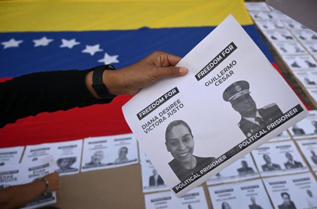 A person holds a sign during a demonstration to demand the freedom of Venezuelan political prisoners at Bolivar square in Bogota on January 18, 2026. (Photo by Raul ARBOLEDA / AFP)