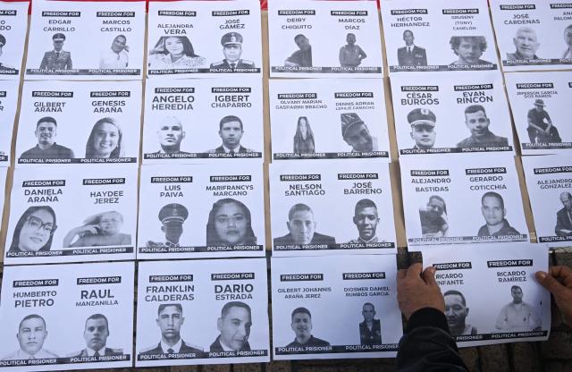 A person arranges a sign during a demonstration to demand the freedom of Venezuelan political prisoners at Bolivar square in Bogota on January 18, 2026. (Photo by Raul ARBOLEDA / AFP)