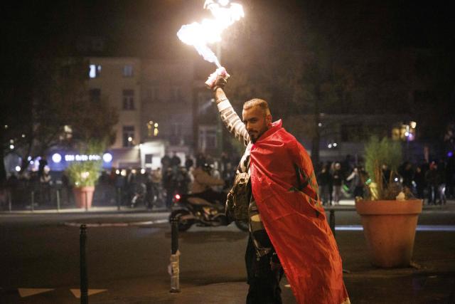 A supporter with a Moroccan national flag sprays fire in Brussels, on January 18, 2026 following the Africa Cup of Nations (AFCON) final football match between Senegal and Morocco played in Rabat, Morocco. Senegal won the Africa Cup of Nations as Pape Gueye's extra-time winner sunk hosts Morocco 1-0 after a chaotic final that saw the eventual champions storm off the pitch late in the game. (Photo by Simon Wohlfahrt / AFP)