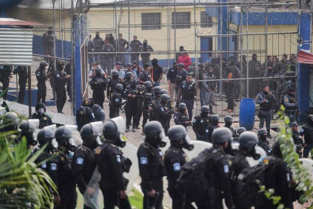 Guatemalan riot police officers guard the entrance to the men's Preventive Detention Center in Guatemala City on January 18, 2026. Guatemala's government accused gang members of killing eight police officers in several attacks on January 18, 2025, after refusing to negotiate the transfer of leaders of these dangerous gangs to a lower-security prison. The killings occurred a day after gang-affiliated inmates took 46 people hostage in three prisons across the country. Police regained control of one of the prisons. (Photo by Edwin BERCIAN / AFP)