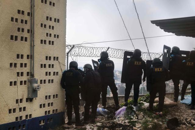 Members of the Guatemalan Police Special Forces Division (FEP) guard the entrance to the men's Preventive Detention Center in Guatemala City on January 18, 2026. Guatemala's government accused gang members of killing eight police officers in several attacks on January 18, 2025, after refusing to negotiate the transfer of leaders of these dangerous gangs to a lower-security prison. The killings occurred a day after gang-affiliated inmates took 46 people hostage in three prisons across the country. Police regained control of one of the prisons. (Photo by Edwin BERCIAN / AFP)