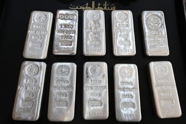 (FILES) Silver bars are displayed at a shop in downtown Kuwait City on January 12, 2026. Gold and silver prices hit record highs on January 12 after US President Donald Trump threatened to hit several top European countries with tariffs over their opposition to the US takeover of Greenland, sparking fresh trade war fears. (Photo by YASSER AL-ZAYYAT / AFP)