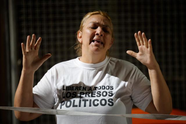 A woman gestures during a vigil to demand the freedom of Venezuelan political prisoners near Zona 7 prison in Caracas on January 18, 2026. (Photo by Pedro MATTEY / AFP)