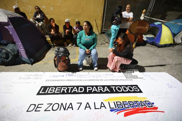 People attend a vigil to demand the freedom of Venezuelan political prisoners near Zona 7 in Caracas on January 18, 2026. (Photo by Pedro MATTEY / AFP)