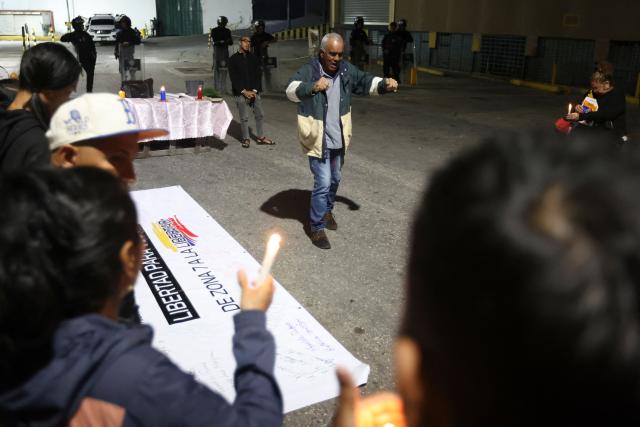 People attend a vigil to demand the freedom of Venezuelan political prisoners near Zona 7 prison in Caracas on January 18, 2026. (Photo by Pedro MATTEY / AFP)