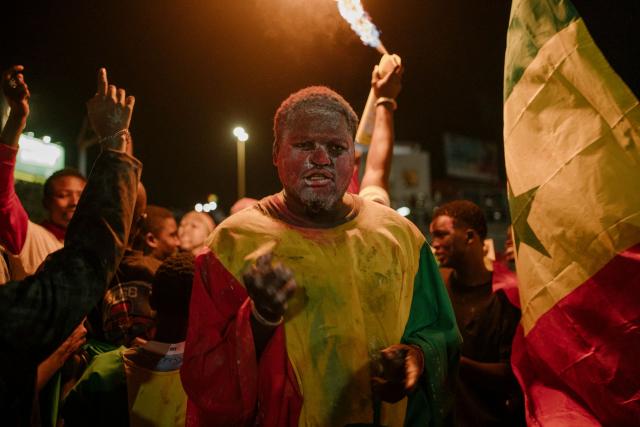 A Senegal supporter celebrates at a fan zone at the African Renaissance Monument in Dakar on January 18, 2026 after watching Senegal defeat Morocco in the Africa Cup of Nations (CAN) final football match being played in Rabat, Morocco. (Photo by Carmen Abd Ali / AFP)