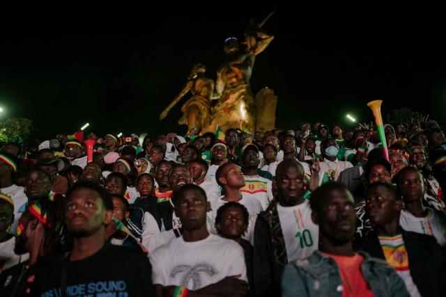 Senegal supporters celebrate at a fan zone at the African Renaissance Monument in Dakar on January 18, 2026 after watching Senegal defeat Morocco in the Africa Cup of Nations (CAN) final football match being played in Rabat, Morocco. (Photo by Carmen Abd Ali / AFP)