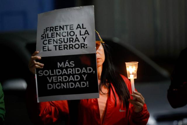 A woman shows a sign during a vigil to demand the freedom of Venezuelan political prisoners near Zona 7 prison in Caracas on January 18, 2026. (Photo by Pedro MATTEY / AFP)