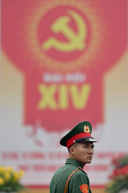A soldier stands in front of a billboard for the 14th Congress of the Communist Party of Vietnam outside the National Convention Center in Hanoi on January 19, 2026. Vietnam's ruling Communist Party convened on January 19 to begin their twice-a-decade congress, where leader To Lam is looking to tighten his grip on power less than two years after assuming the top role. (Photo by Nhac NGUYEN / AFP)
