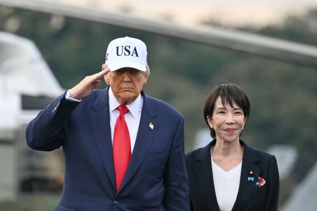 (FILES) US President Donald Trump (L) and Japan's Prime Minister Sanae Takaichi arrive on board the US Navy's USS George Washington aircraft carrier at the US naval base in Yokosuka on October 28, 2025. Takaichi said on January 19, 2026 she wanted to ask the public if she is 'fit' to be premier after announcing plans to dissolve parliament for a snap election. (Photo by ANDREW CABALLERO-REYNOLDS / AFP)