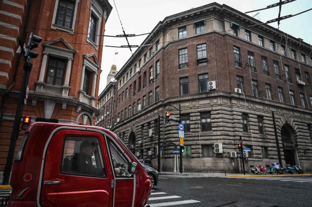 A man drives a vehicle on a street in Shanghai on January 19, 2026. China's economy grew at one of the slowest rates in decades last year, according to official data released on January 19, as officials struggle to overcome persistently low consumer spending and a debt crisis in the country's property sector. (Photo by Jade GAO / AFP)