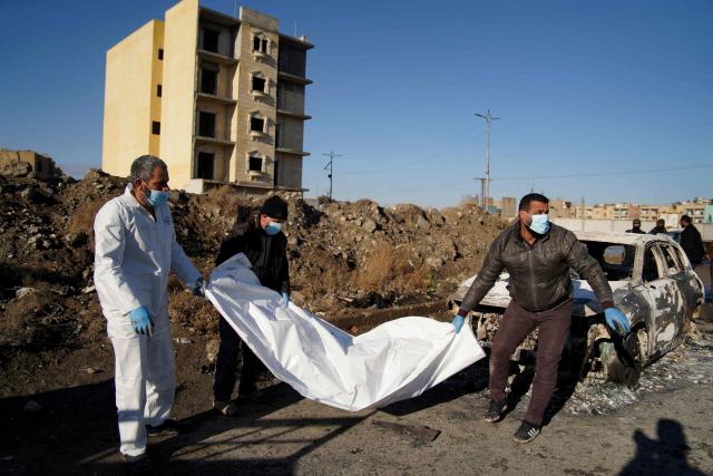 Syrian Civil Defence employes remove from the side of a road a body bag containing a Kurdish fighter, the day after a ceasefire was called between the Syrian Ministry of Defense forces and Kurdish fighters, in the northern Syrian city of Raqa, on January 19, 2026. Syria's army on January 19, 2026, deployed its forces in parts of the eastern Deir Ezzor province formerly controlled by Kurdish forces following their withdrawal from the area. After two days of rapid gains in Kurdish-controlled territory, the Syrian President announced on January 18, a deal with the Kurdish forces which includes a ceasefire and the integration of the Kurdish administration and forces into the central state. (Photo by Abdulwajed HAJ ESTEIFI / AFP)