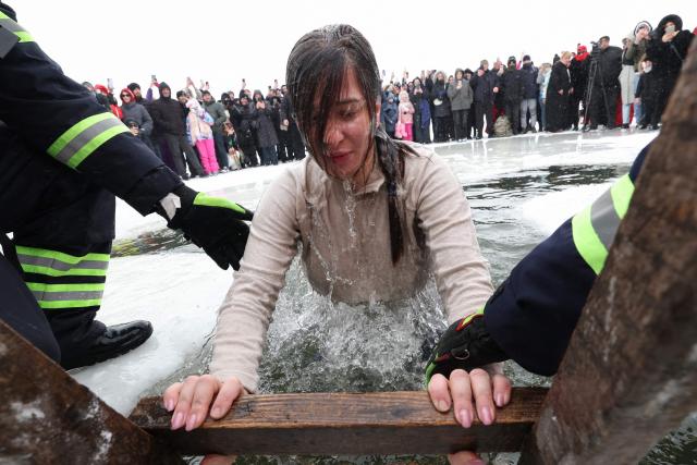 An Orthodox believer plunges into the icy water of Paravani Lake during the Epiphany holiday near Poka, Javakheti region on January 19, 2026. (Photo by Giorgi ARJEVANIDZE / AFP)