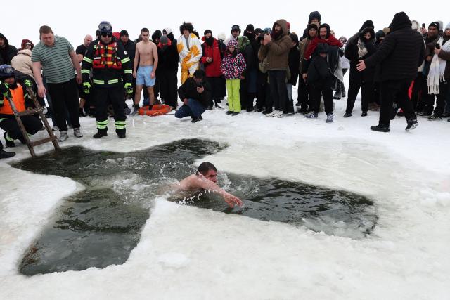 An Orthodox believer swims into the icy water of Paravani Lake during the Epiphany holiday near Poka, Javakheti region on January 19, 2026. (Photo by Giorgi ARJEVANIDZE / AFP)