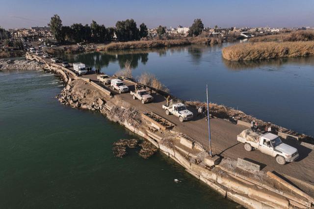 TOPSHOT - Syrian government forces cross the Euphrates River in the province of Deir Ezzor, eastern Syria on January 19, 2026, the day after an agreement between the Syrian government and the Kurdish forces. Syria's army on January 19, deployed its forces in parts of the eastern Deir Ezzor province formerly controlled by Kurdish forces following their withdrawal from the area. After two days of rapid gains in Kurdish-controlled territory, Syrian President announced on January 18, a deal with their that includes a ceasefire and the integration of the Kurdish administration and forces into the central state. (Photo by OMAR HAJ KADOUR / AFP)