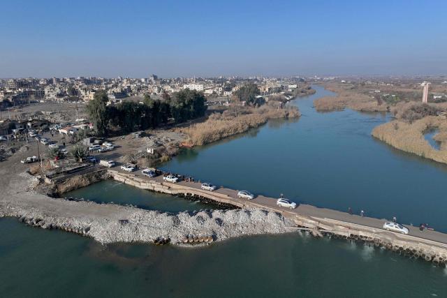 Syrian government forces cross the Euphrates River as they deploy in the province of Deir Ezzor, eastern Syria on January 19, 2026, the day after an agreement between the Syrian government and the Kurdish forces. In Deir Ezzor, an AFP correspondent saw dozens of military vehicles heading to the east of the Euphrates river, which once separated Damascus-controlled areas to the west from the US-backed, Kurdish-led Syrian Democratic Forces to the east. After two days of rapid gains in Kurdish-controlled territory, Syrian President announced on January 18, a deal with their that includes a ceasefire and the integration of the Kurdish administration and forces into the central state. (Photo by OMAR HAJ KADOUR / AFP)