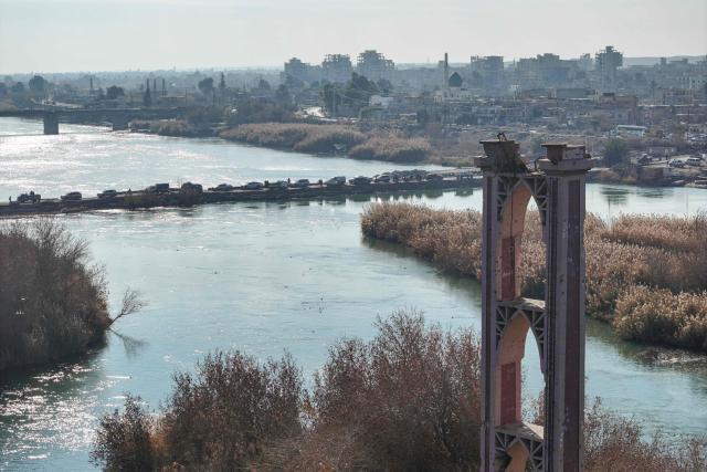 Syrian government forces cross the Euphrates River as they deploy in the province of Deir Ezzor, eastern Syria on January 19, 2026, the day after an agreement between the Syrian government and the Kurdish forces. In Deir Ezzor, an AFP correspondent saw dozens of military vehicles heading to the east of the Euphrates river, which once separated Damascus-controlled areas to the west from the US-backed, Kurdish-led Syrian Democratic Forces to the east. After two days of rapid gains in Kurdish-controlled territory, Syrian President announced on January 18, a deal with their that includes a ceasefire and the integration of the Kurdish administration and forces into the central state. (Photo by OMAR HAJ KADOUR / AFP)