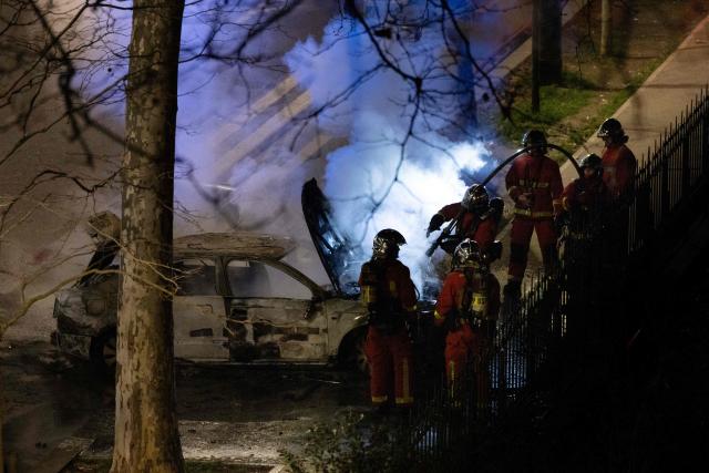 Firefighters extinguish a car that caught fire following incidents during celebrations after the Africa Cup of Nations (CAN) football final, in the 18th arrondissement of Paris on January 19, 2026. (Photo by JOEL SAGET / AFP)