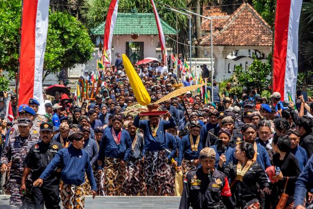 Palace attendants known as abdi dalem carry offerings during the 'Labuhan Laut' ritual of the Yogyakarta Palace, expressing gratitude for the sea's blessings by casting offerings into the ocean at the Parangkusumo Beach in Bantul, Yogyakarta on January 19, 2026. (Photo by DEVI RAHMAN / AFP)