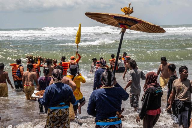 Palace attendants known as abdi dalem carry offerings during the 'Labuhan Laut' ritual of the Yogyakarta Palace, expressing gratitude for the sea's blessings by casting offerings into the ocean at the Parangkusumo Beach in Bantul, Yogyakarta on January 19, 2026. (Photo by DEVI RAHMAN / AFP)