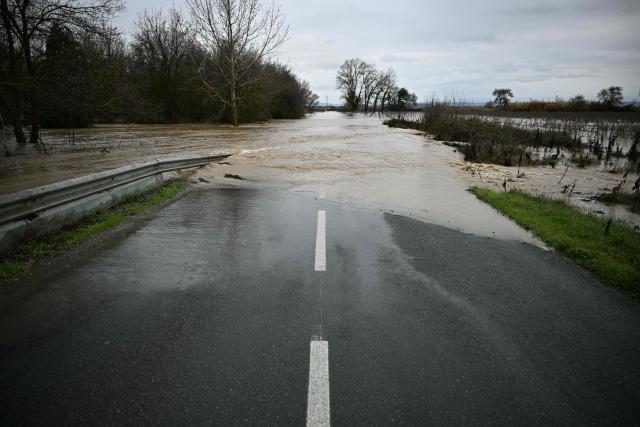 A photo shows a flooded road due to the overflowing of the River Aude following heavy rainfall in Coursan, southwestern France, on January 19, 2026. (Photo by Lionel BONAVENTURE / AFP)