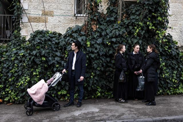 A man stands with a pram at the site where faulty heating system left two babies dead and many others injured at a day care in Jerusalem on January 19, 2026. Israeli doctors declared two babies dead after medics evacuated 55 children from a daycare centre in Jerusalem on January 19, with local media reporting the incident may have been linked to the facility's heating system. (Photo by JOHN WESSELS / AFP)