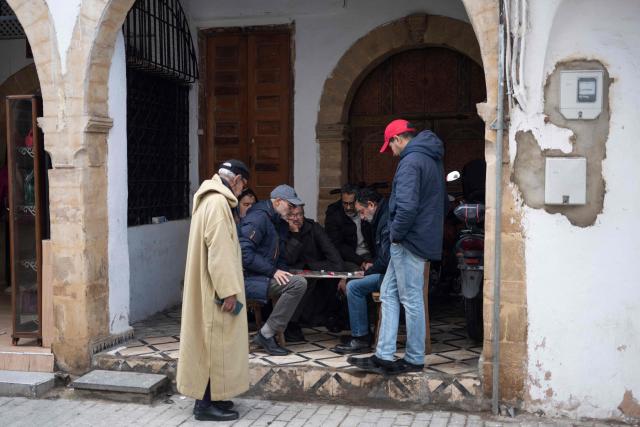 People play a board game in a market area in the old quarters of Rabat on January 19, 2026. (Photo by Jewel SAMAD / AFP)