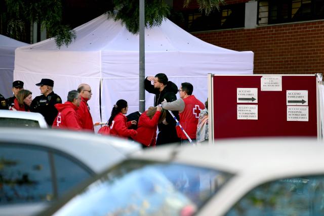 Red Cross workers walk toward the emergency center set near the site where a high-speed Iryo train derailed and was hit by another train as rescue efforts continue in Adamuz, southern Spain, on January 19, 2026. At least 39 people died and more than 120 injured in the deadliest train accident in Spain in over a decade. The crash happened on January 18, 2026 evening when a train operated by rail company Iryo travelling from Malaga to Madrid derailed near Adamuz, crossing onto the other track where it crashed into an oncoming train, which also derailed. (Photo by CRISTINA QUICLER / AFP)
