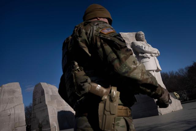 A member of the National Guard walks past the Martin Luther King, Jr. Memorial on the National Mall during Martin Luther King Jr. Day on January 19, 2026 in Washington, DC. (Photo by Brendan Smialowski / AFP)