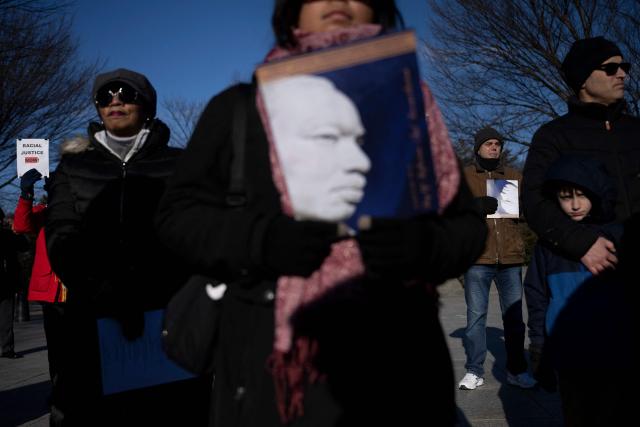 People listen to speakers during a celebration of Martin Luther King Jr. Day at the Martin Luther King, Jr. Memorial on the National Mall on January 19, 2026 in Washington, DC. (Photo by Brendan Smialowski / AFP)