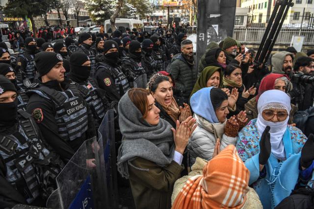 Protesters stand in front of police officers during a demonstration against the attacks by the Syrian government forces, in Diyarbalir, on January 19, 2026. Despite heavy snow, at least 500 protesters rallied on January 19, 2026 in Diyarbakir, the main city in the Kurdish-majority southeast, where clashes erupted as police tried to stop them marching, an AFP correspondent said. Syria's army took control of swathes of the country's north on Saturday, dislodging Kurdish forces from territory over which they held effective autonomy for over a decade. (Photo by Ilyas AKENGIN / AFP)