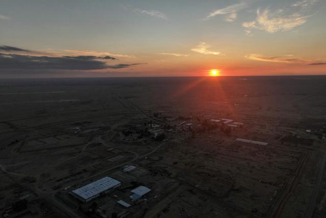 An areal photograph shows the sun setting over of the Al-Omar oil field in Syria’s eastern Deir Ezzor province on January 19, 2026. Syria's army deployed in formerly Kurdish-led areas in the country's east and north on January 19, after a ceasefire announced a day earlier. The Kurdish-led Syrian Democratic Forces (SDF) on January 18, withdrew from areas under its control in the eastern Deir Ezzor countryside, including the Al-Omar oil field. (Photo by Omar HAJ KADOUR / AFP)