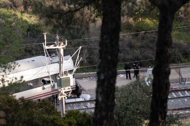 Spain's Guardia Civil agents work at the site of an Iryo train that derailed and was hit by another train the day before, killing at least 39 people and injuring more than 120, in Adamuz, southern Spain, on January 19, 2026. At least 39 people died and more than 120 injured in the deadliest train accident in Spain in over a decade. The crash happened on January 18, 2026 evening when a train operated by rail company Iryo travelling from Malaga to Madrid derailed near Adamuz, crossing onto the other track where it crashed into an oncoming train, which also derailed. (Photo by JORGE GUERRERO / AFP)