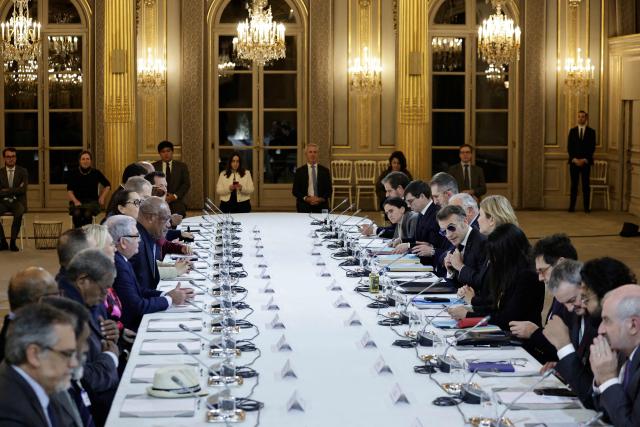 French President Emmanuel Macron (6R) talks with flanked by the National Assembly's President Yael Braun-Pivet (5R) as he leads a meeting on New-Caledonia at the Elysee Palace in Paris on January 19, 2026. (Photo by STEPHANE DE SAKUTIN / POOL / AFP)