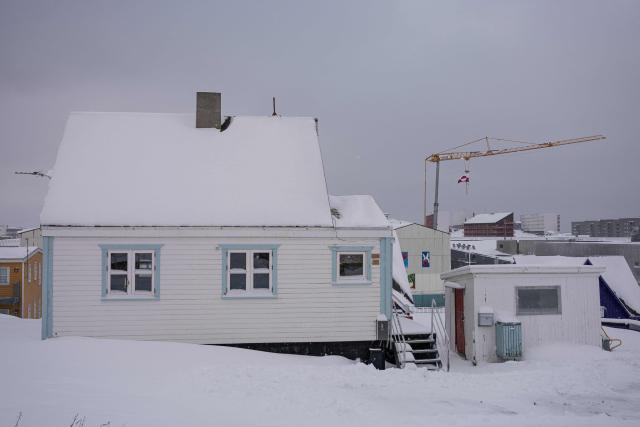 The Greenland flag hangs from a crane at a construction site in Nuuk, Greenland, on January 19, 2026. (Photo by Jonathan NACKSTRAND / AFP)
