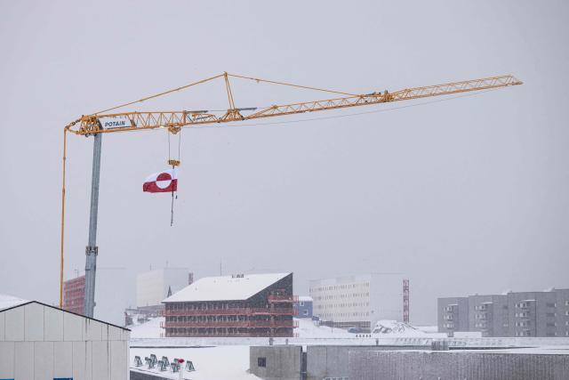 The Greenland flag hangs from a crane at a construction site in Nuuk, Greenland, on January 19, 2026. (Photo by Jonathan NACKSTRAND / AFP)