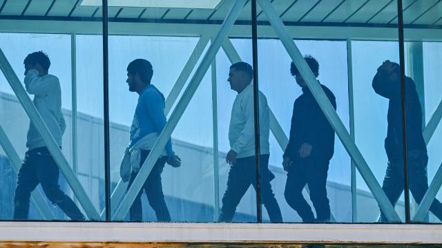 Venezuelan migrants deported from the United States walk upon arrival at Simon Bolivar International Airport in Maiquetia, Venezuela on January 19, 2026. (Photo by Juan BARRETO / AFP)